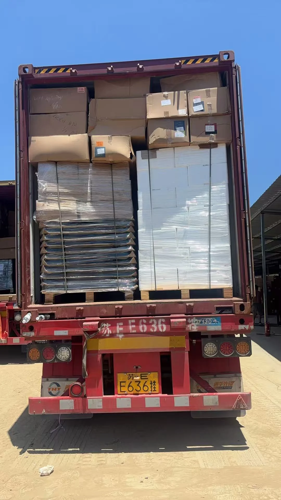 Cartons and protected vehicle parts arranged during container loading preparation